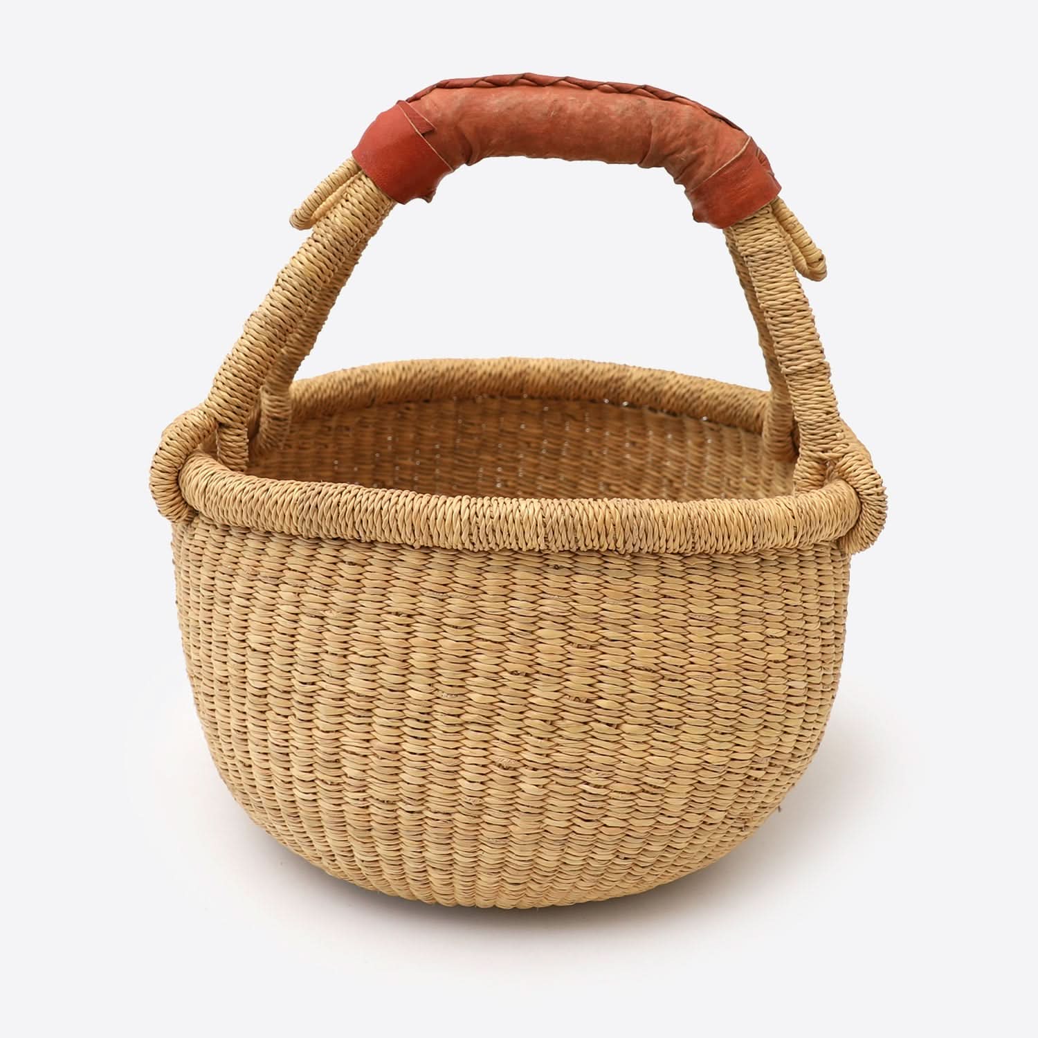 Natural raffia wool woven storage basket with leather handle on white background.
