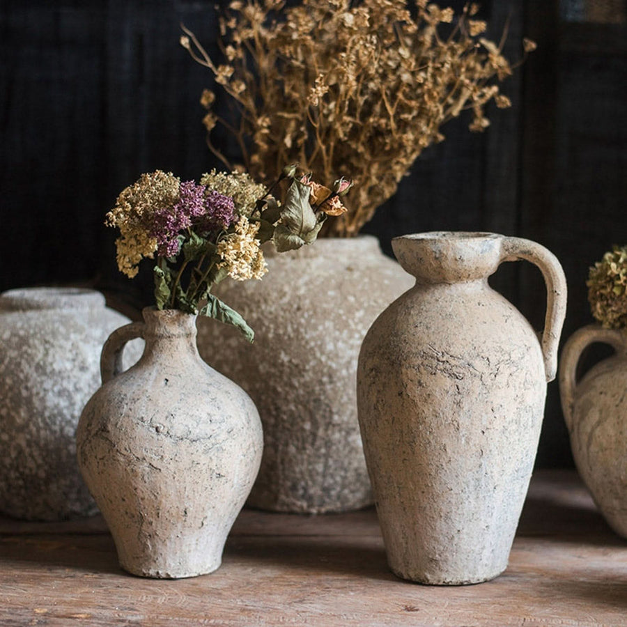 Rustic red clay pots with ears, featuring dried flowers for home decor.