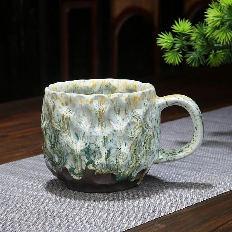 Retro handmade stoneware coffee cup, colourful reactive glaze paint-drop design on pottery.
