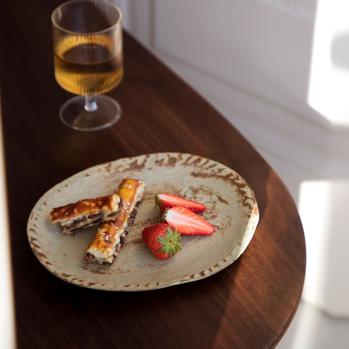 Rustic brown irregular flat plate, hand-made, with pastry and strawberries.