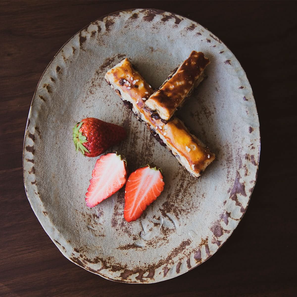 Rough Pottery Rustic Brown Irregular Flat Plate with strawberries and pastries