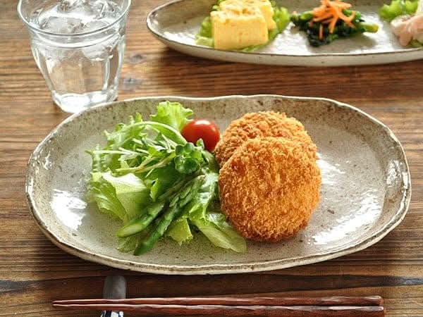 Rough Pottery Stoneware Dinner Set with salad and fried patties on a textured plate.