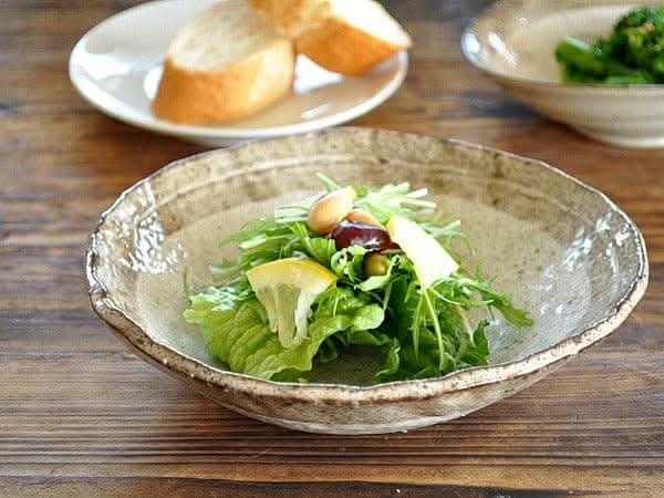 Rough Pottery Stoneware Dinner Set with salad and bread on wooden table