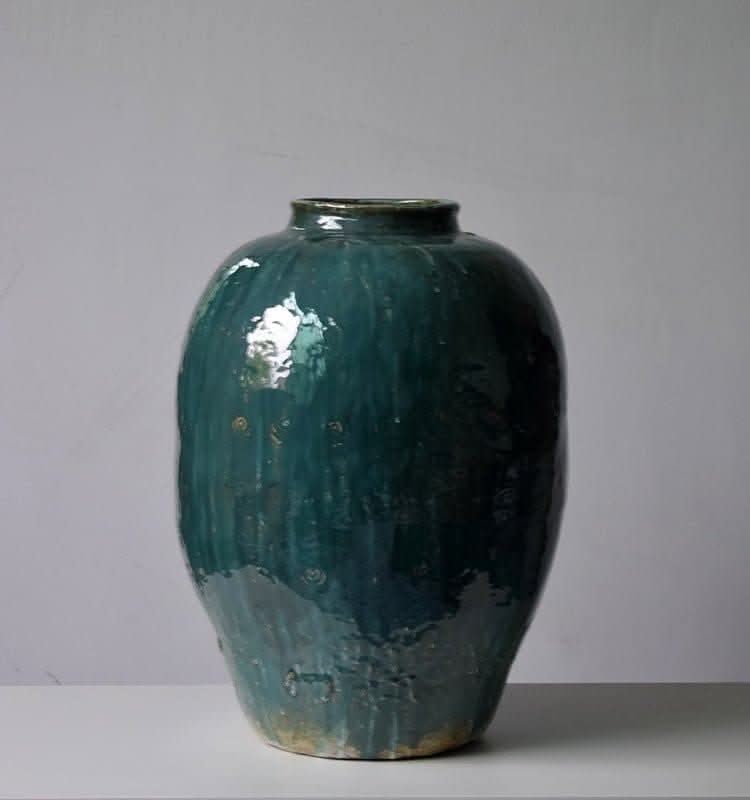 Rustic Distressed Rounded Vase with dark green blue glaze, circular engraved pattern, on white surface.