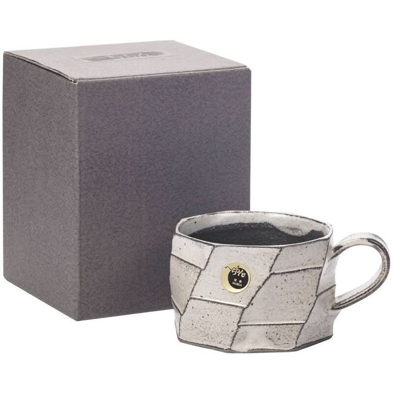 Rustic hand-made carved white stoneware mug from Japan, with textured glaze.