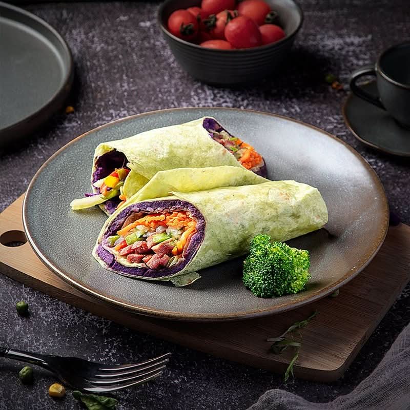 Rustic Plates Ceramic Breakfast Set with colorful wraps, broccoli, and cherry tomatoes on a dark grey plate.