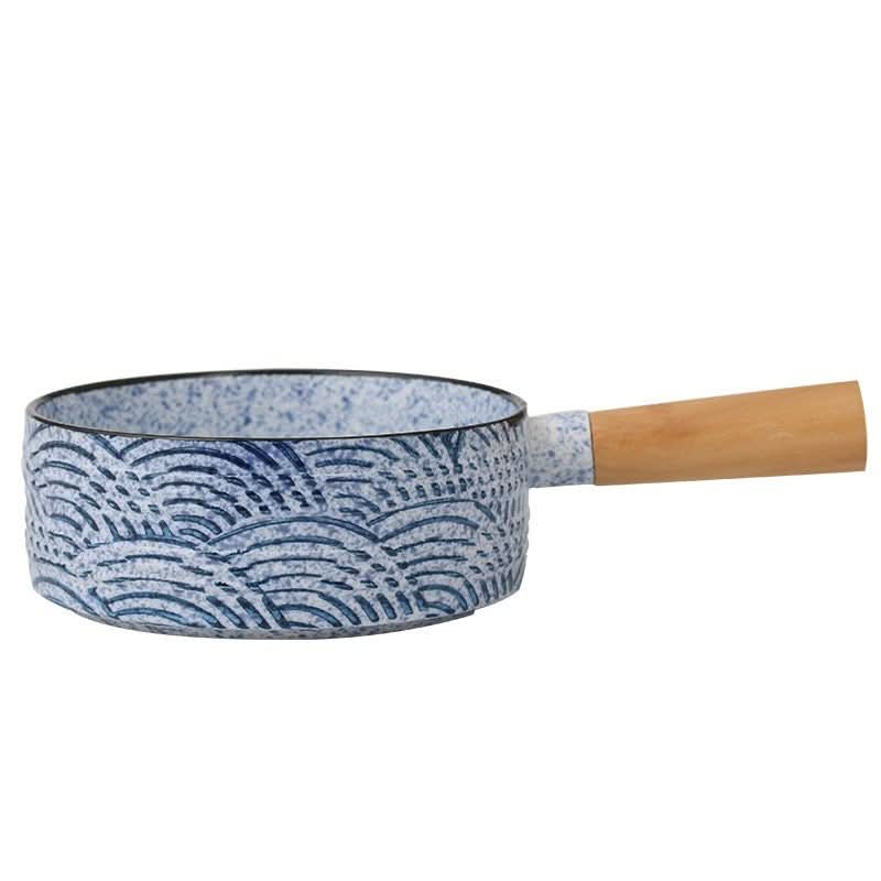 Rustic stoneware baking plate with Japanese wave art, blue and white ceramic with wooden handle.