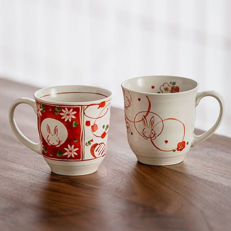 Sakura Rabbit Couple Mug Set: hand-painted ceramic mugs with red and white floral rabbit designs.