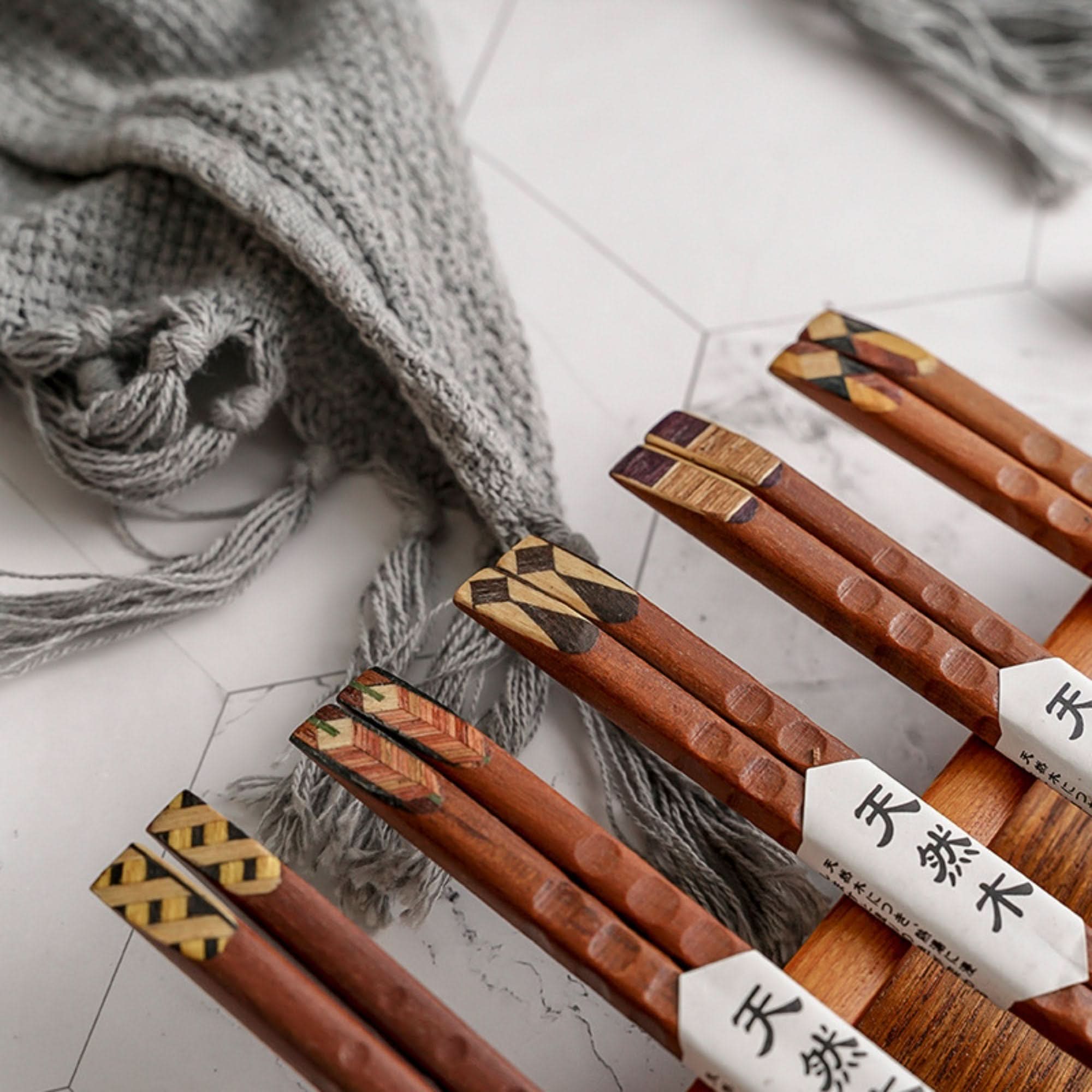 Set of 10 pairs natural wooden chopsticks with colored decorative upper parts.