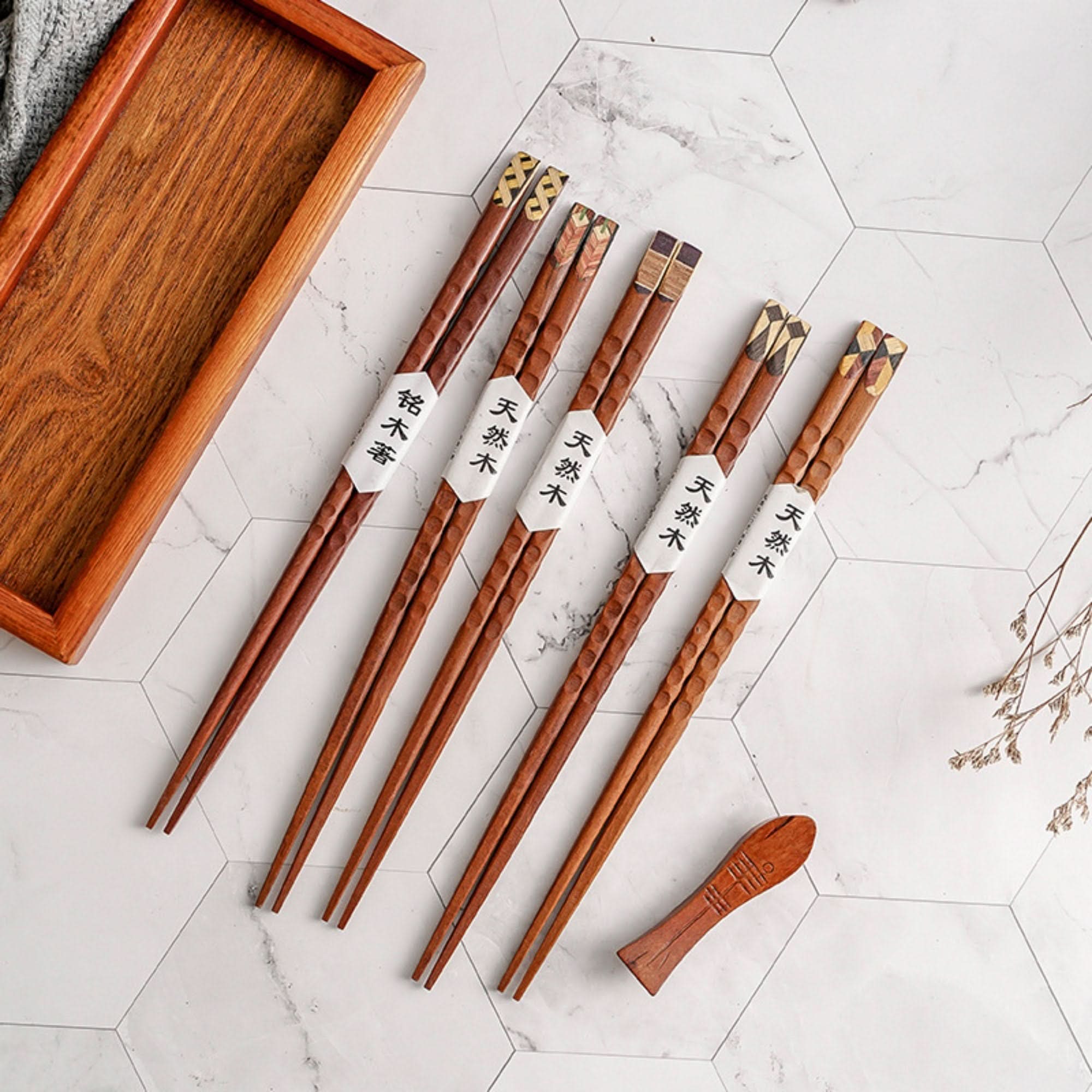 Set of 10 pairs natural wooden chopsticks with colored tops, Japanese, Chinese, Zen style, on marble background.