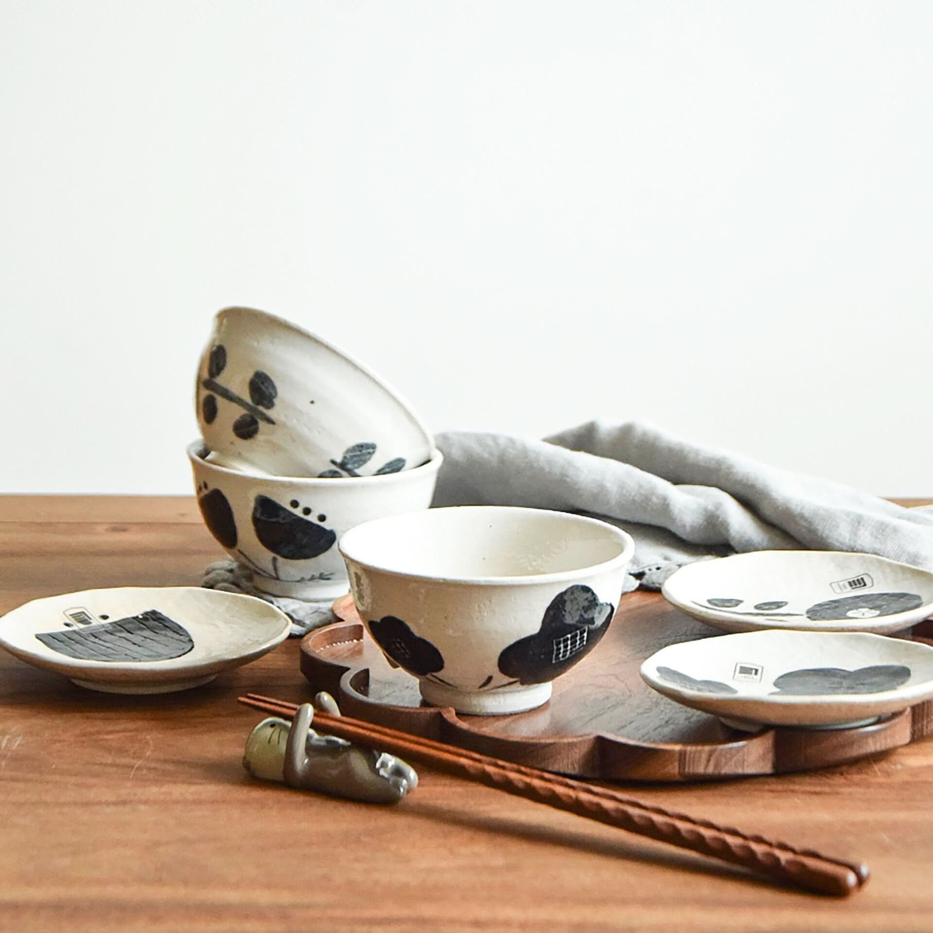 Seto Yaki Slimline Flower Small Plate, handmade black & white Japanese art on ceramic, displayed on wood.