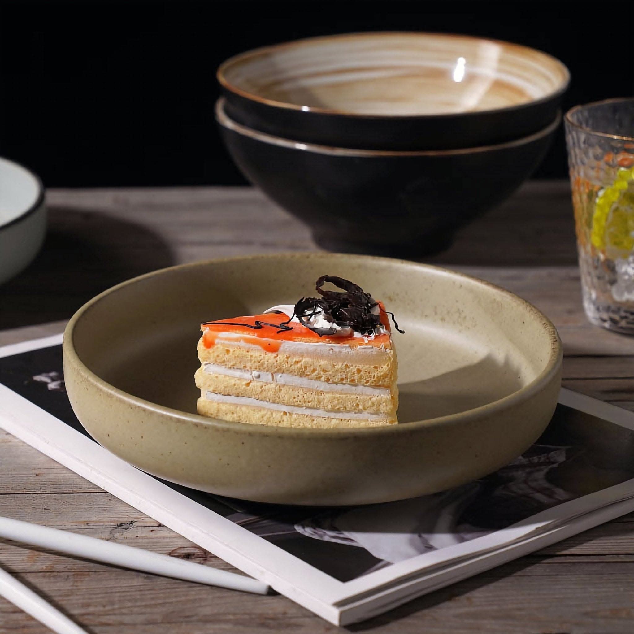 Earthy-toned ceramic shallow plate holding a slice of cake.