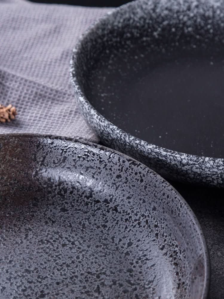 Two speckled grey Shallow Plates With Gradients ceramic dishes on a textured grey cloth.
