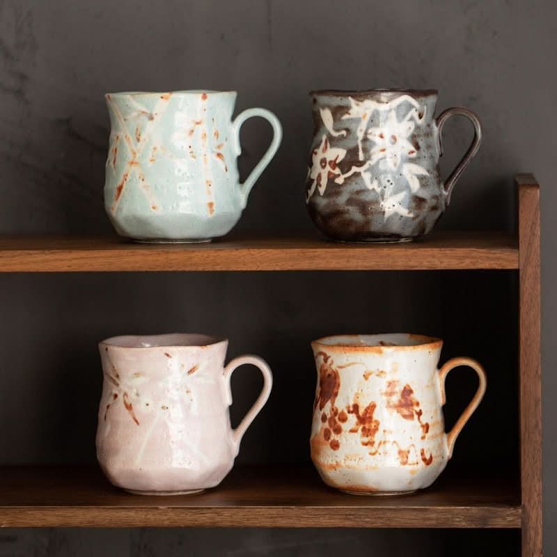 Four Shino-Yaki ceramic mugs in pastel colors with rustic Japanese designs.