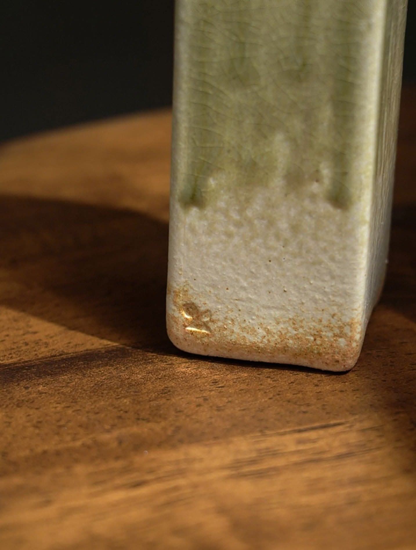 Shigaraki ceramic slab pottery flower vase, light green glaze, textured on wood.