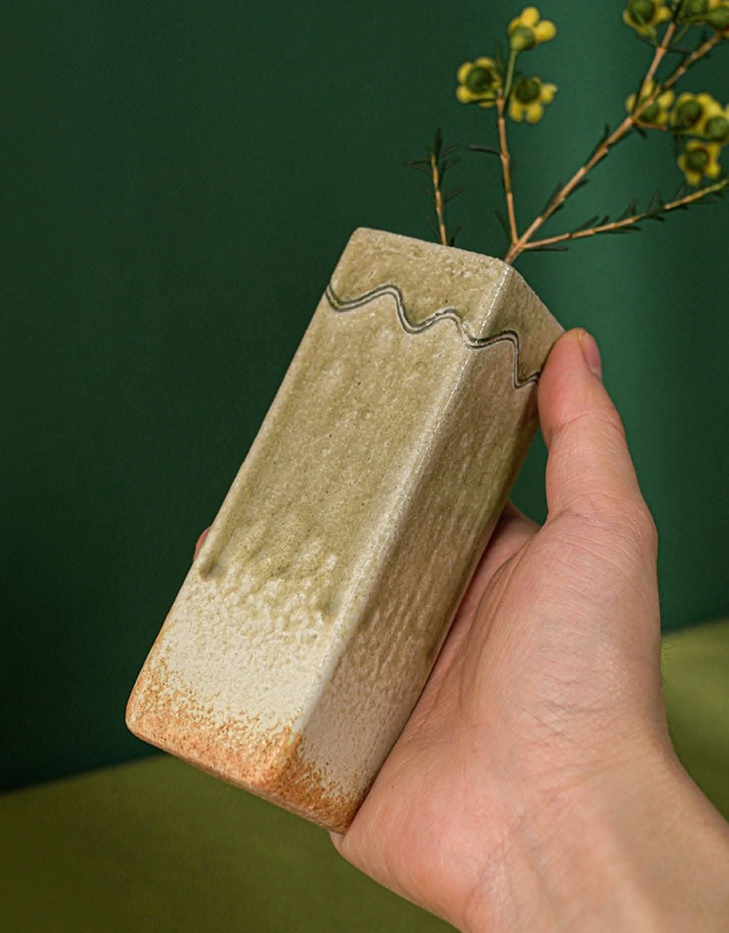 Shigaraki ceramic vase, green and tan, imported from Japan, holding yellow flowers.