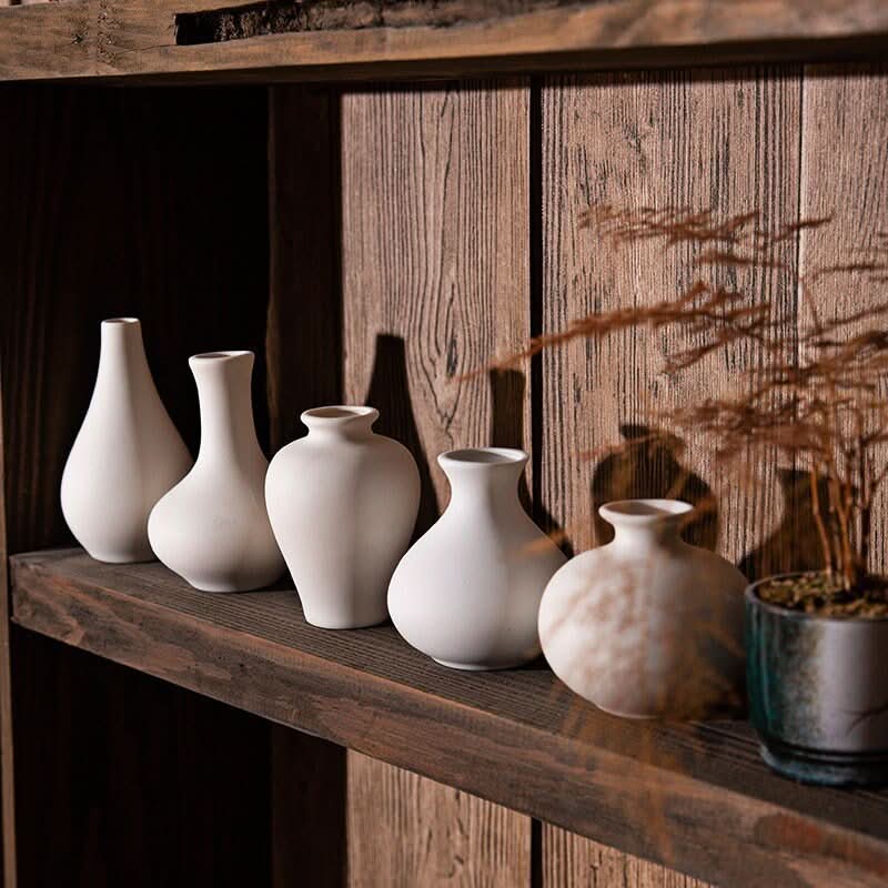 Small Ceramic White Bud Vases on a wooden shelf with dried plant.