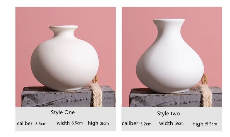 Two small ceramic white bud vases, Scandinavian style, on rustic stands.