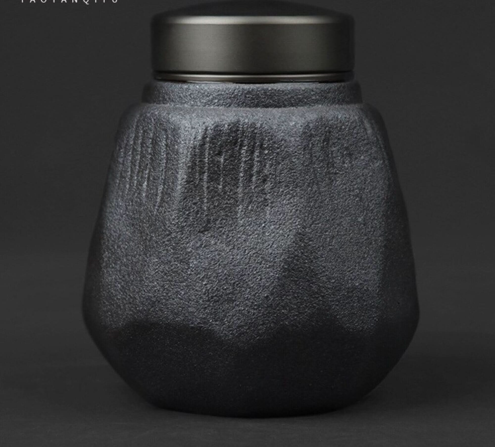 Small grey stoneware sealed tea can with textured finish and dark lid.