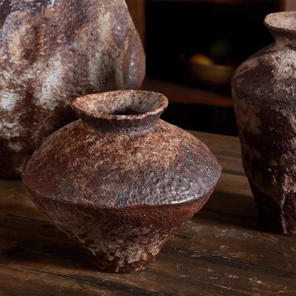 Rustic brown Wabi Sabi ceramic vase for flowers, textured finish on wooden table.