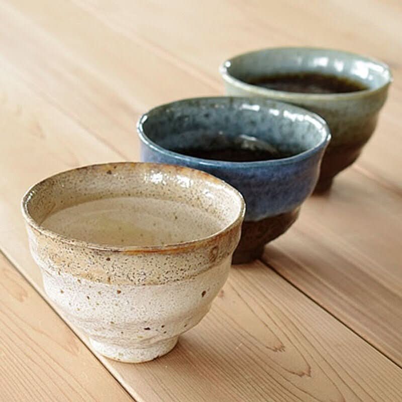 Three ceramic ramen bowls 14.54oz with speckled earthy tones and blue glaze on a wood table.