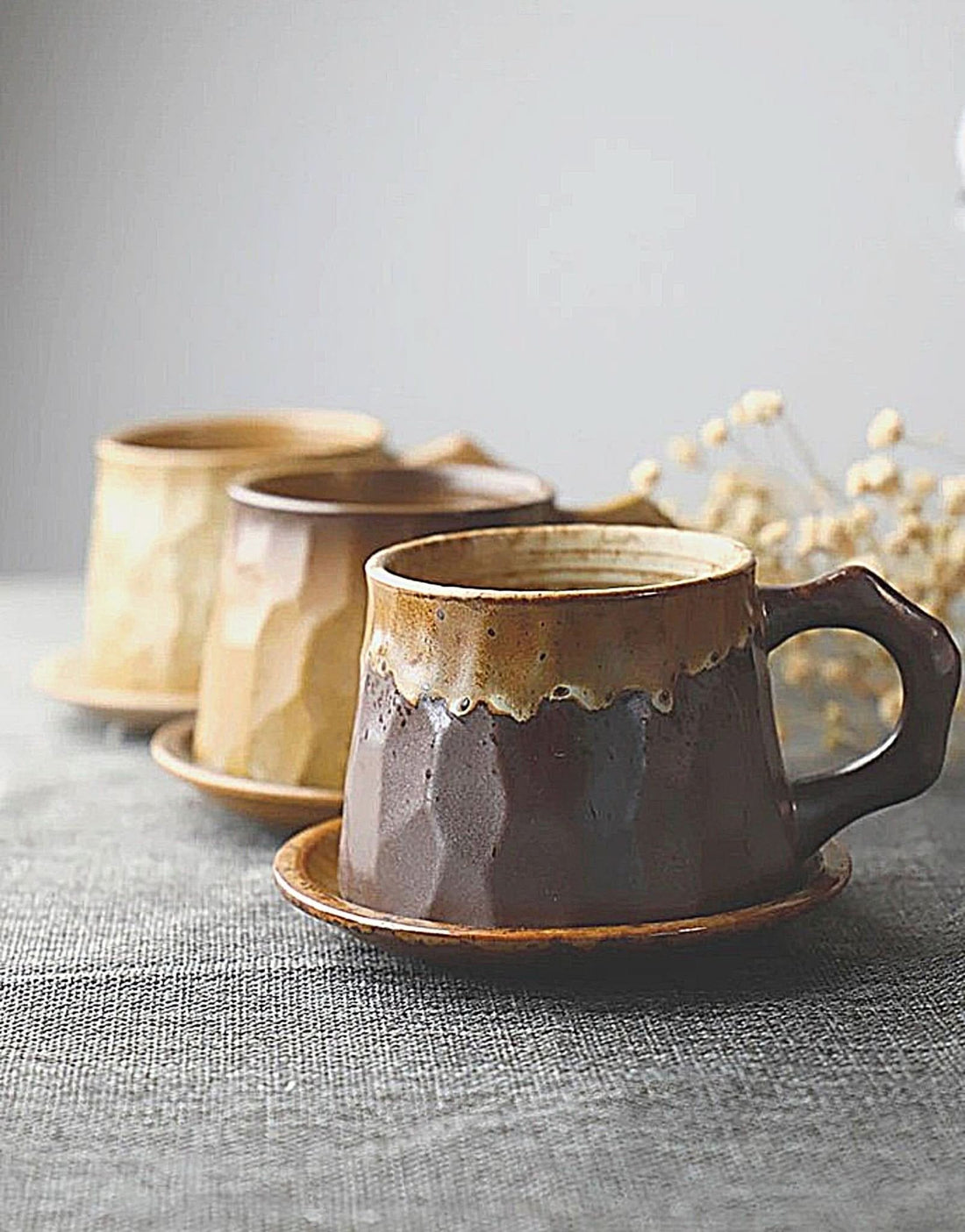 Stoneware mug with saucer, brown and beige, textured design. 10oz capacity.