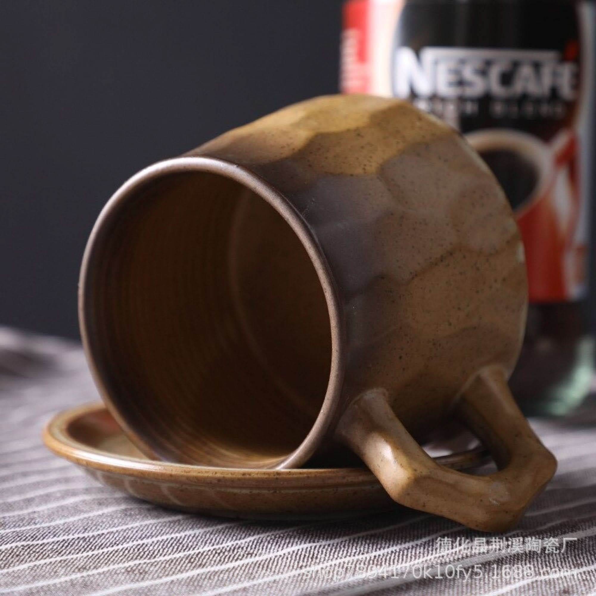 Brown speckled stoneware mug 10.14oz + free saucer on striped cloth.