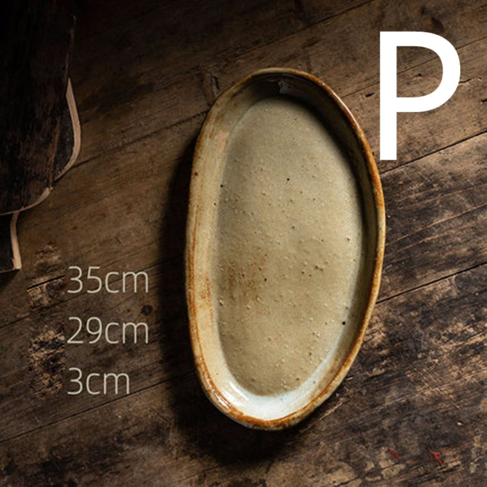Stoneware handmade irregular ice cracked ceramic tableware, beige oval dish on wooden surface.