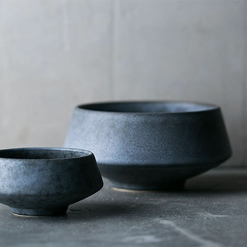 Dark speckled stoneware mat bowl, 700ml, on a textured surface.