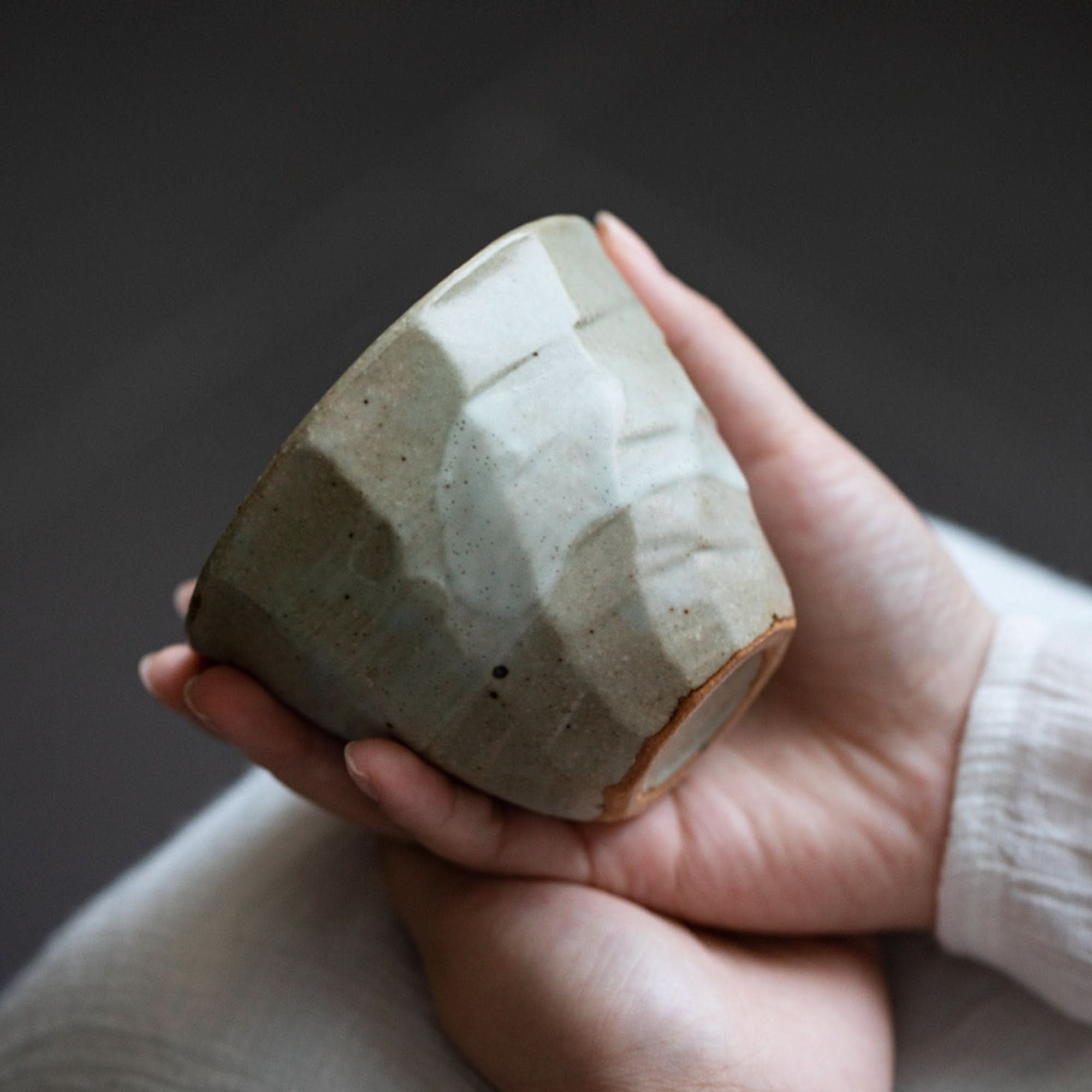 Hands holding textured Japanese Cups Set 9.4oz, beige and white ceramic, minimalist home decor.