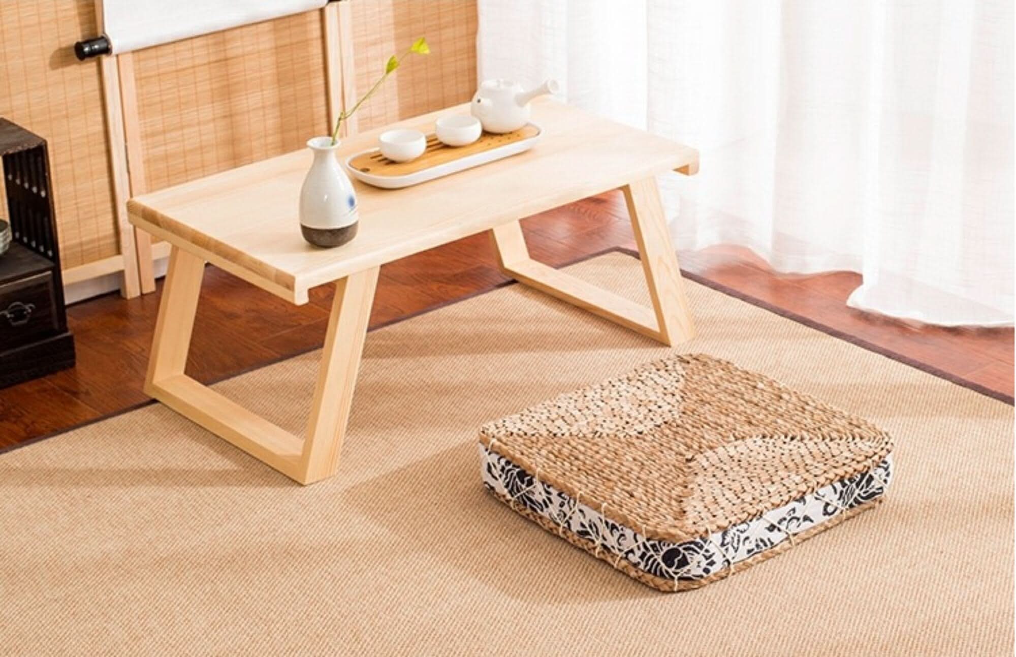 Straw floor pouf with fabric decor on a rug, natural boho home decor.