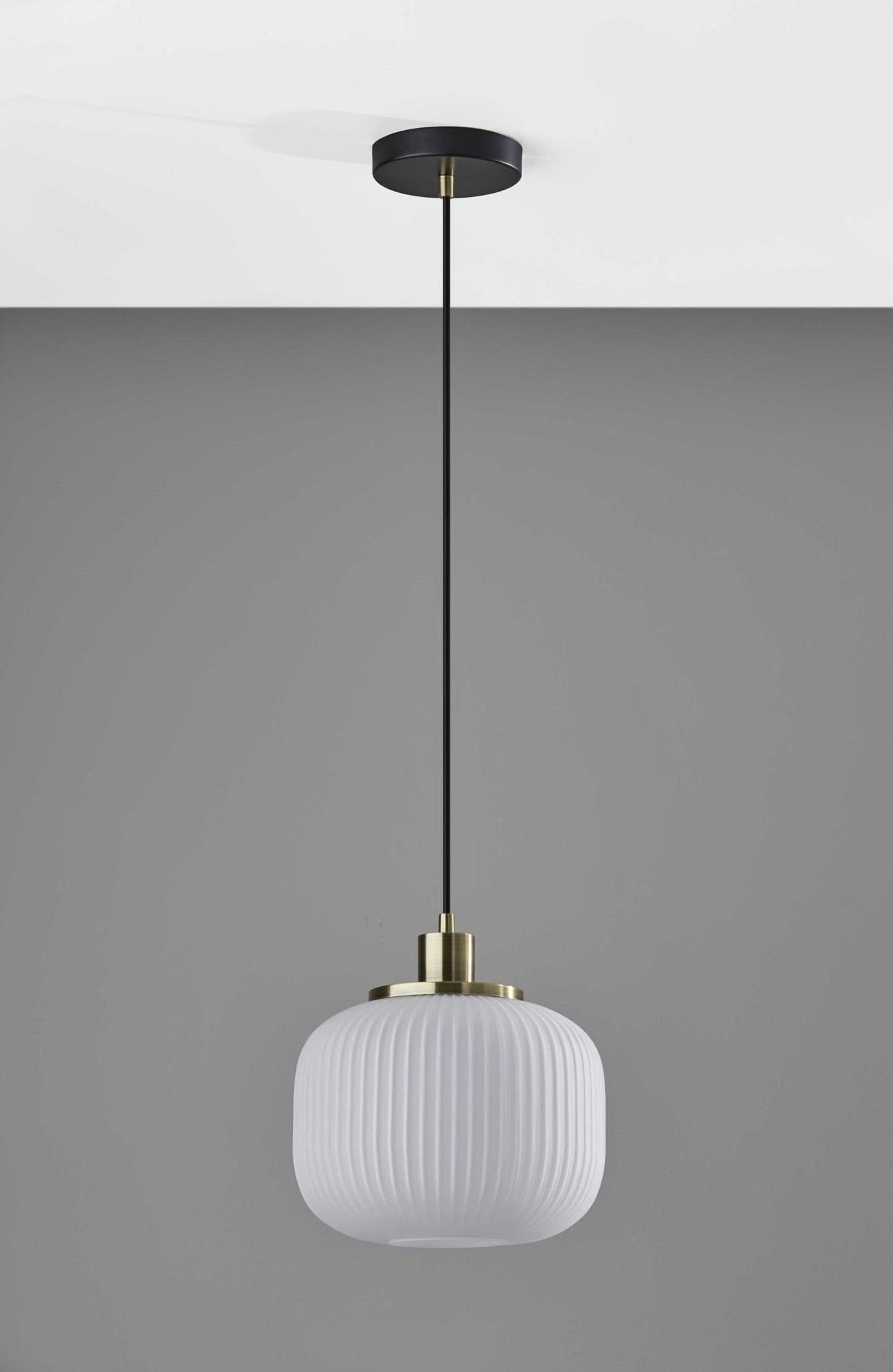 Striped Glass Glow Metal Pendant with brass fitting and black ceiling rose, illuminated.