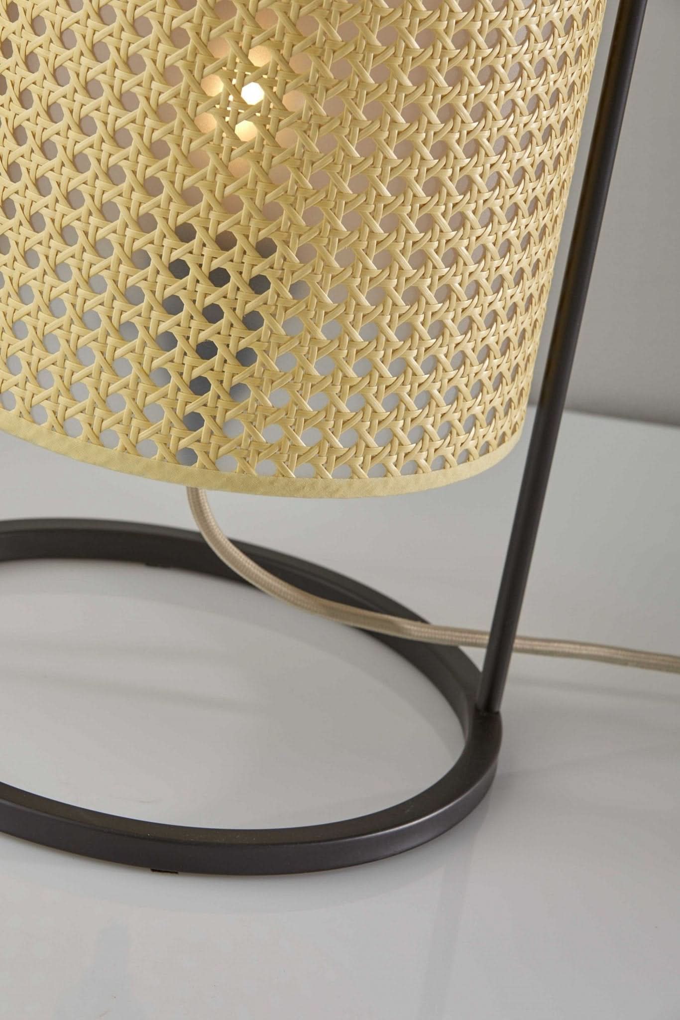 Tall Cane Shade Table Lamp with dark metal base and natural woven texture, on a white surface.