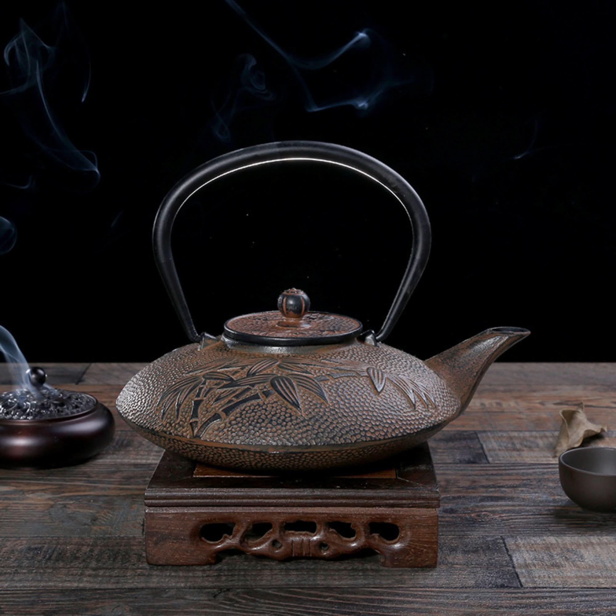 Rustic brown Iron Cast Tea Kettle with bamboo design on wooden stand, rising smoke, dark background.