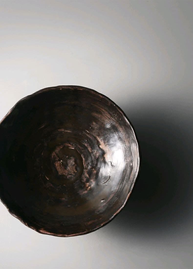 Tripod Stoneware Ceramic Irregular Fruit Bowl in dark brown with textured finish.