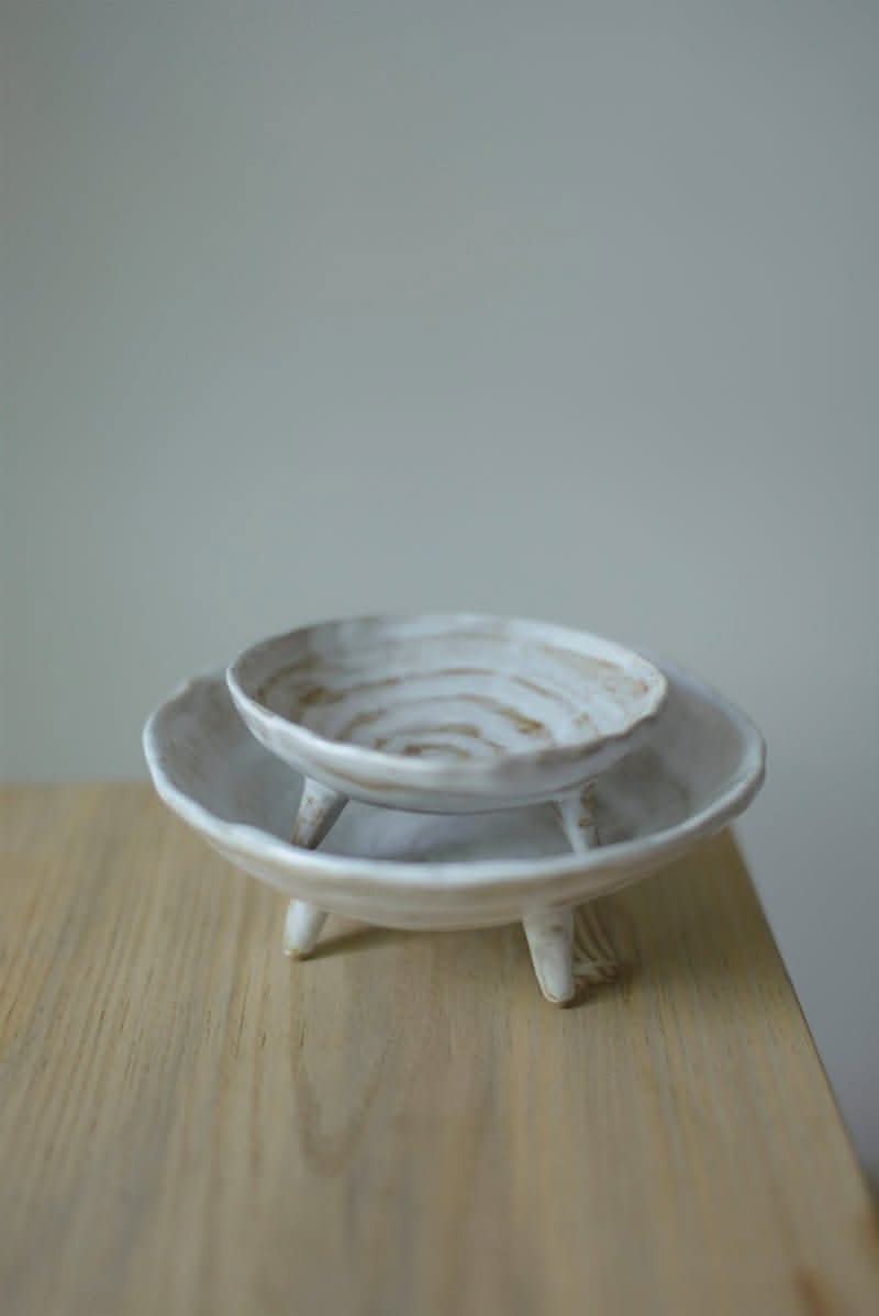 Tripod Stoneware Ceramic Irregular Fruit Bowl, off-white textured ceramic on wooden surface.