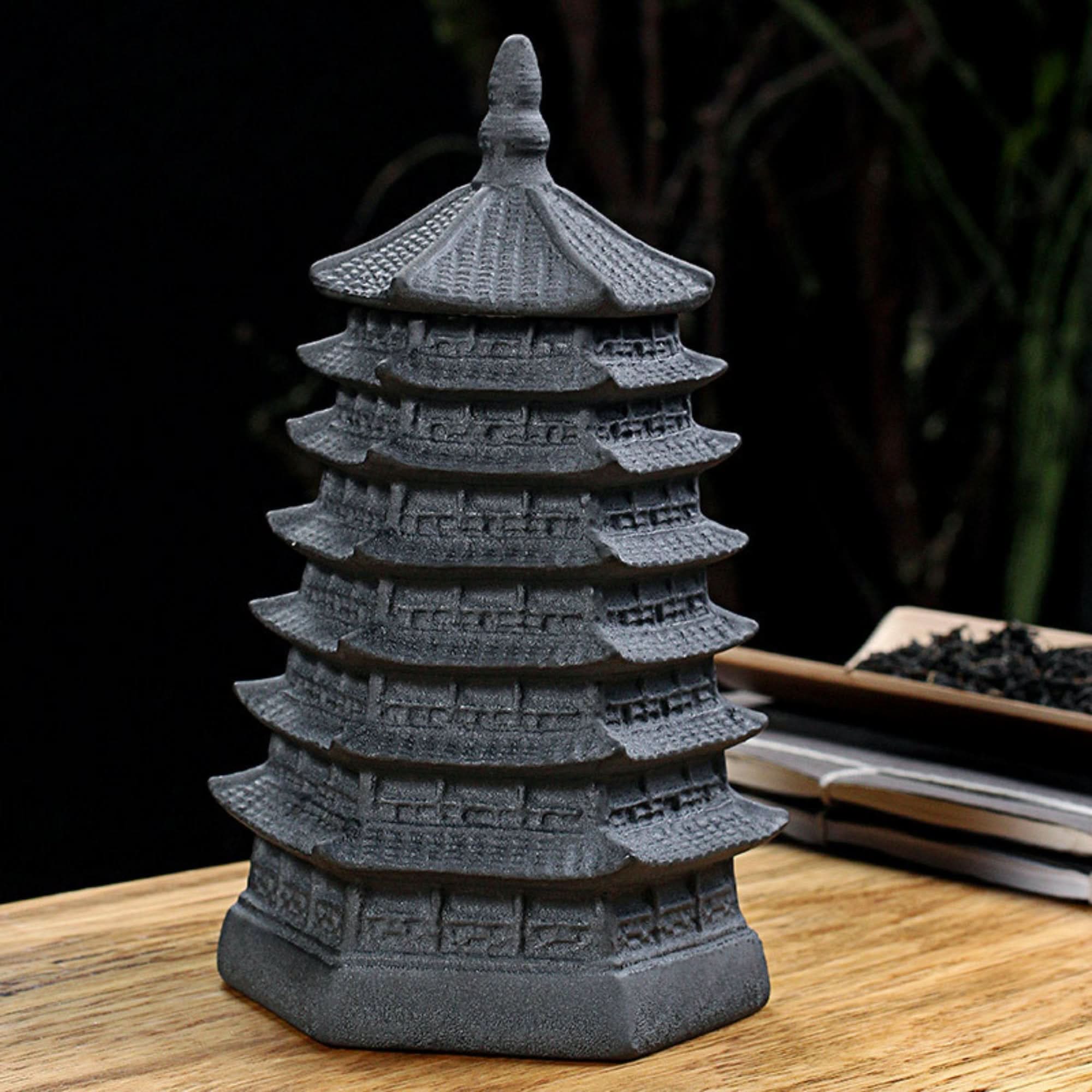 Vintage Japanese tea jar canister in dark grey ceramic, shaped like a pagoda, on wood.