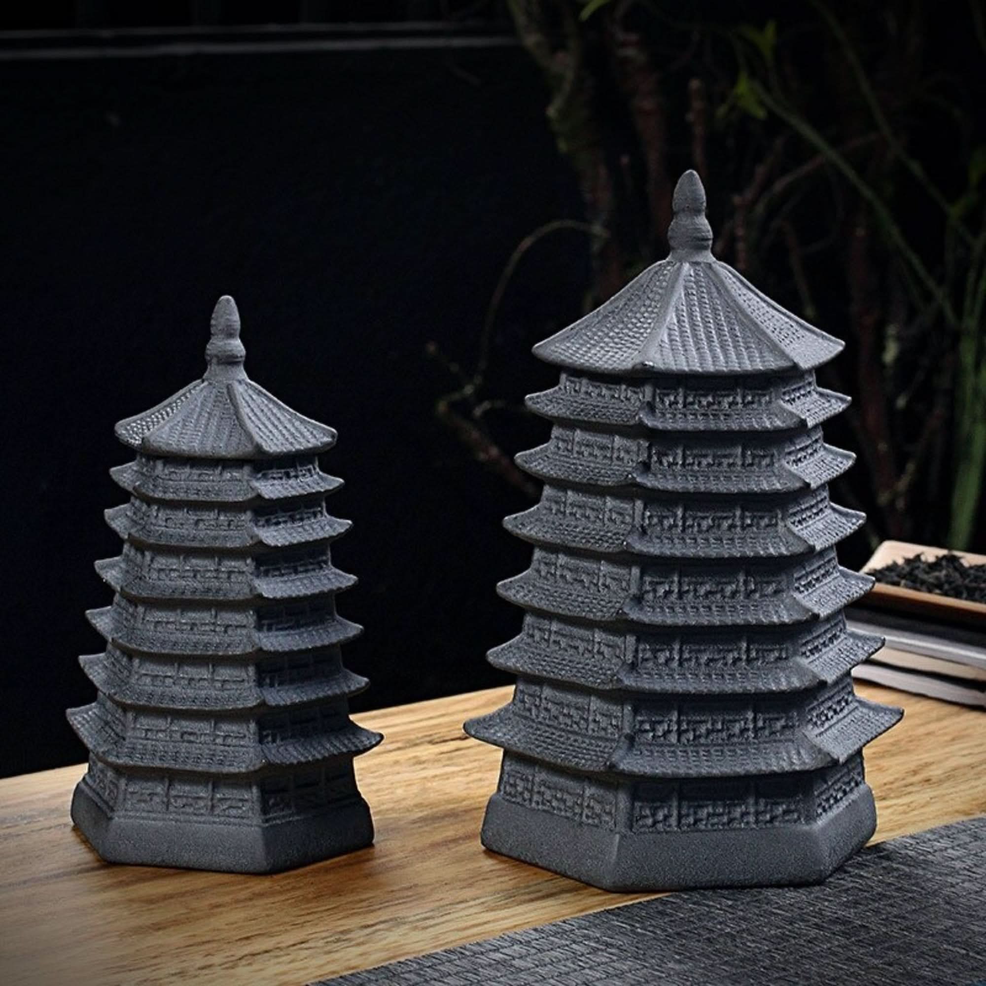 Two vintage Japanese-style kitchen canisters in textured gray, resembling pagoda architecture, on a wooden surface.
