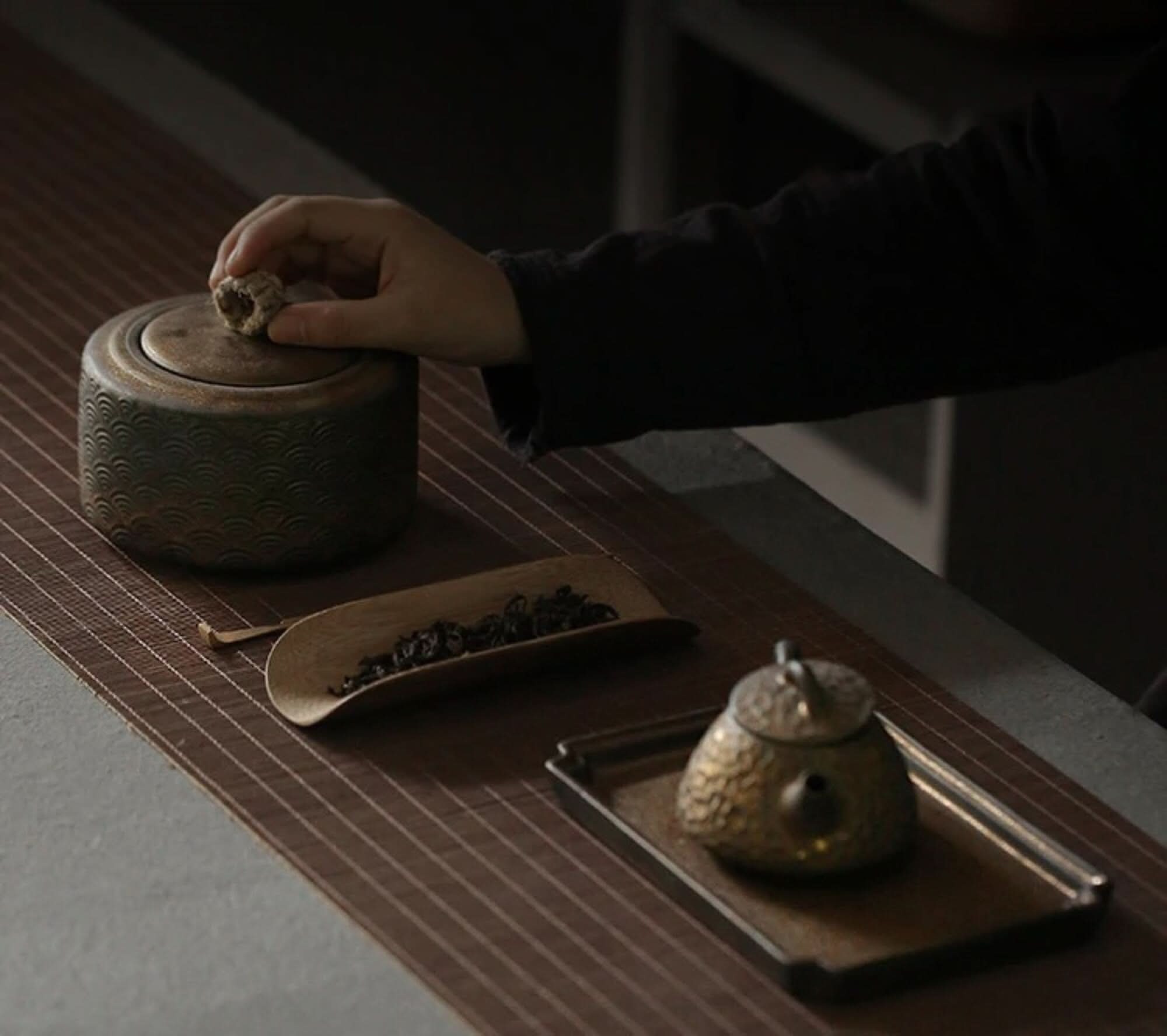 Vintage kitchen canister, Japanese tea jar, black tea, on bamboo mat.