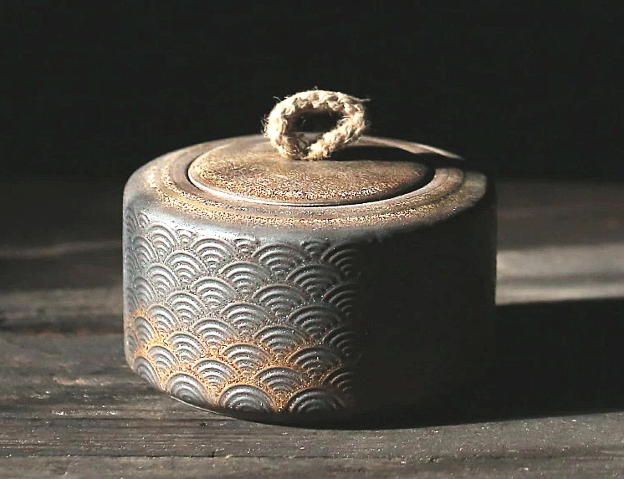 Vintage kitchen canister with Japanese wave pattern, featuring textured ceramic and twine handle.