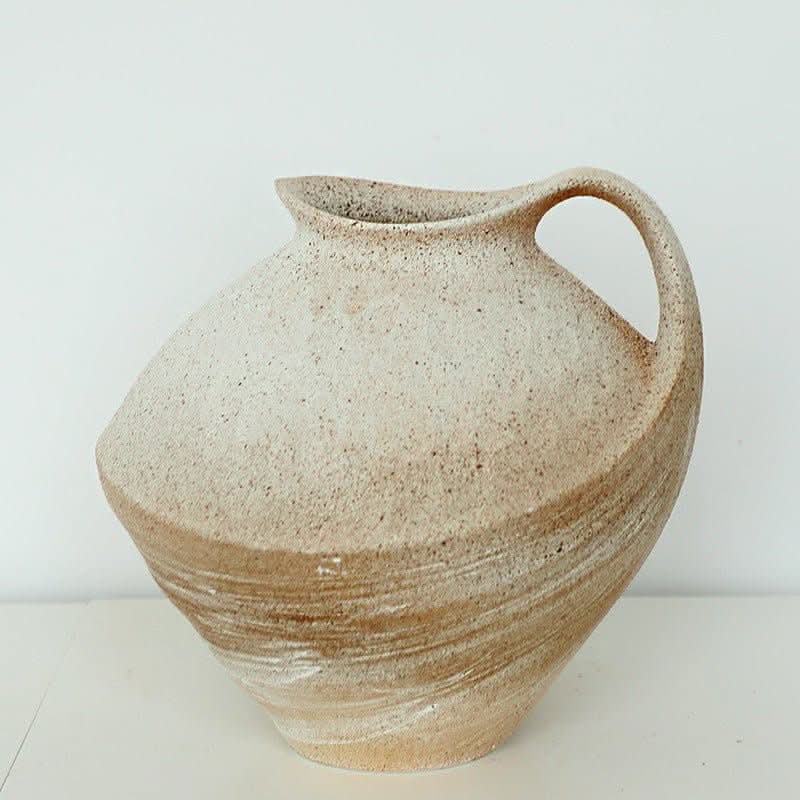 Wabi-sabi clay pot with brush effect, textured stoneware with handle on white surface.