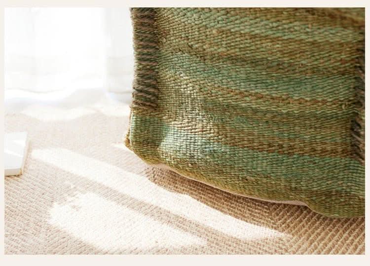 Wabi-sabi jute ottoman footstool, green & brown woven texture, on natural rug.