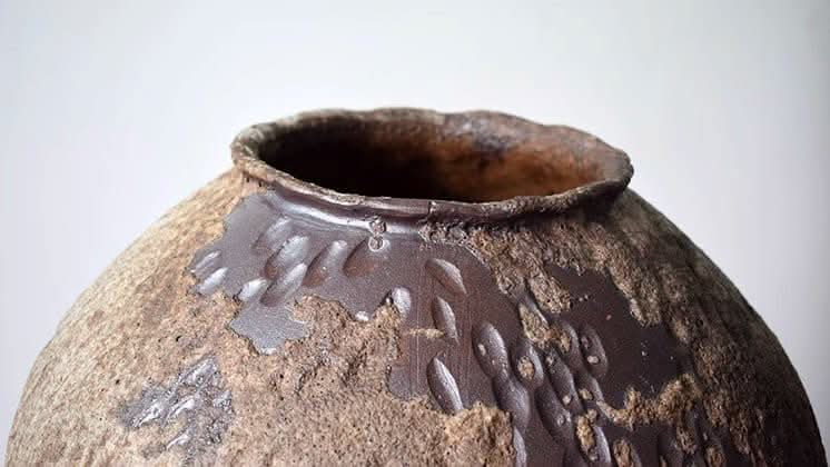Wabi-Sabi Rounded Ceramic Vase: distressed texture, hammered detail, brown and gray hues.