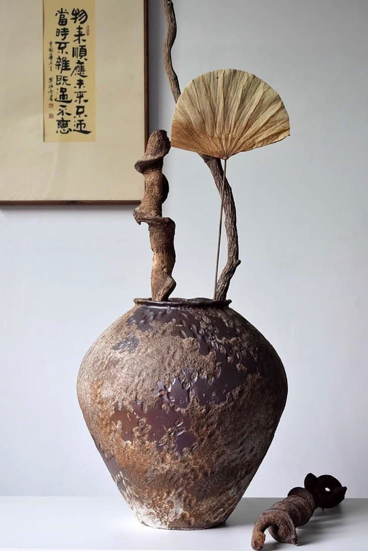 Wabi-Sabi rounded ceramic vase, hammered distressed texture, brown tones, with dried branches & fan decor.