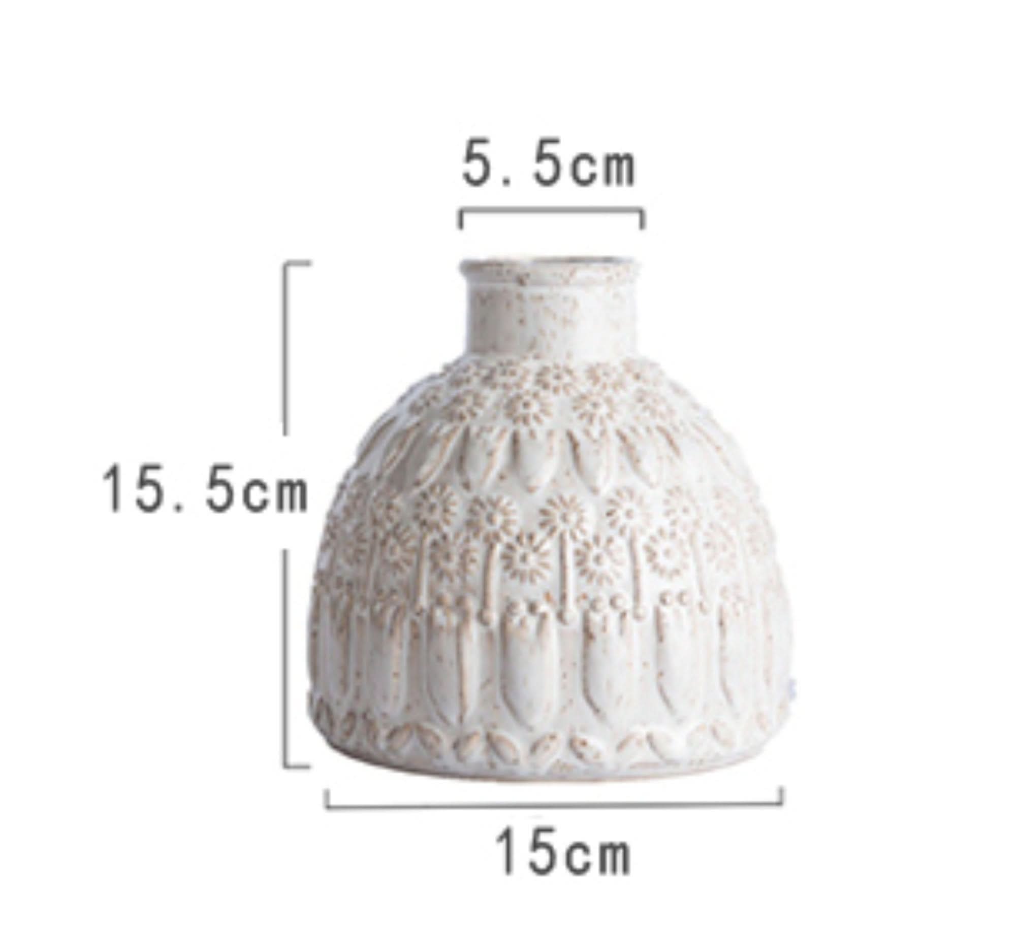 White ceramic small vase with embossed floral pattern, home decor accent.