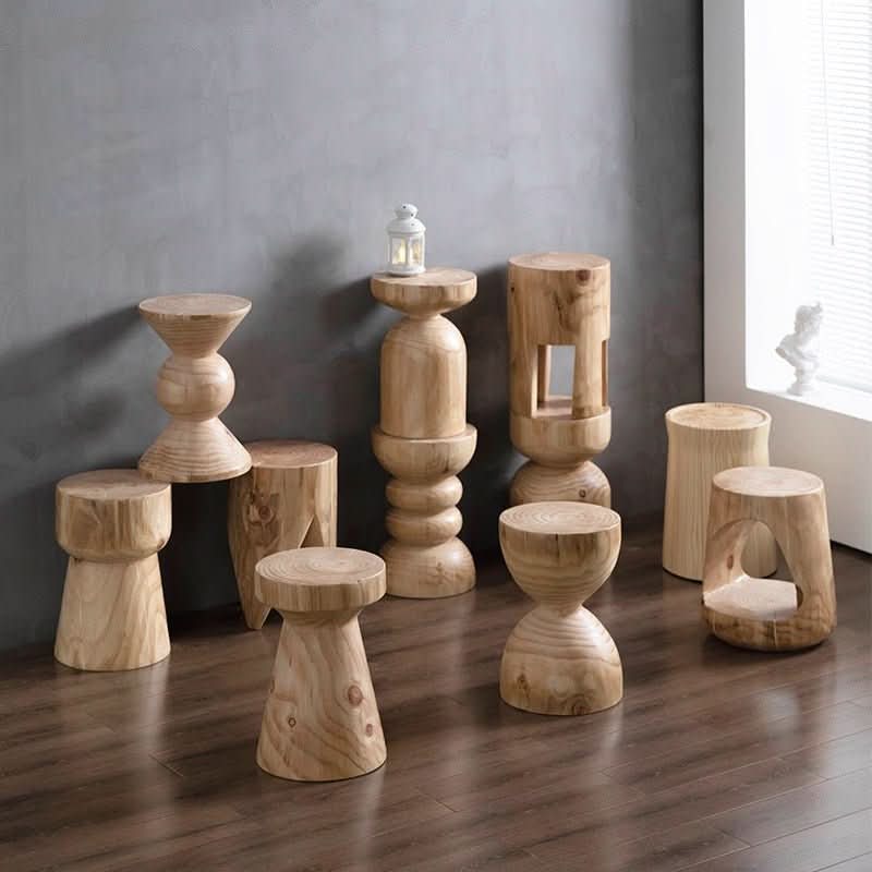 Natural wood stools, customizable size, displayed on a dark floor against a gray wall.